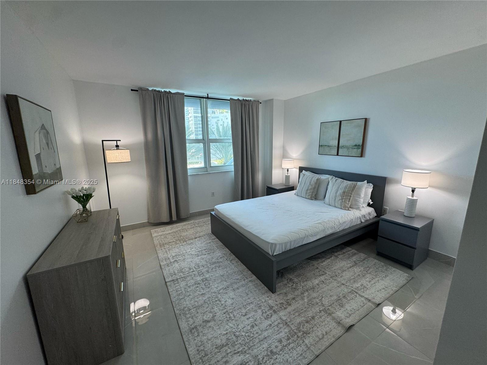 1155 Brickell Bay Drive, Unit 307 Miami, FL 33131 - Photo 15 of 23 a bedroom with a large bed and a chandelier