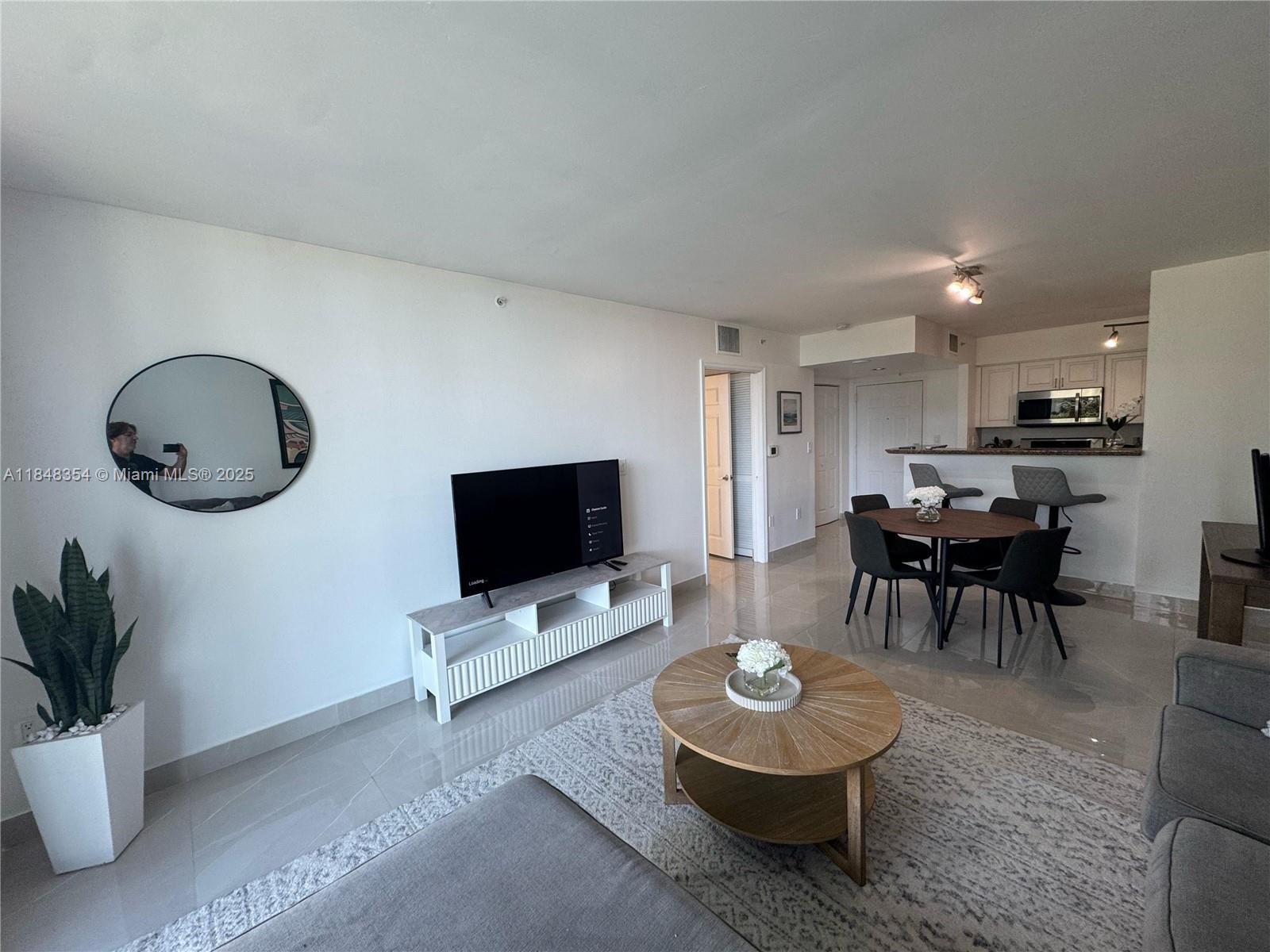 1155 Brickell Bay Drive, Unit 307 Miami, FL 33131 - Photo 2 of 23 a living room with furniture and a flat screen tv