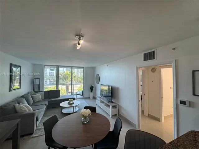 a living room with furniture a large window and a chandelier