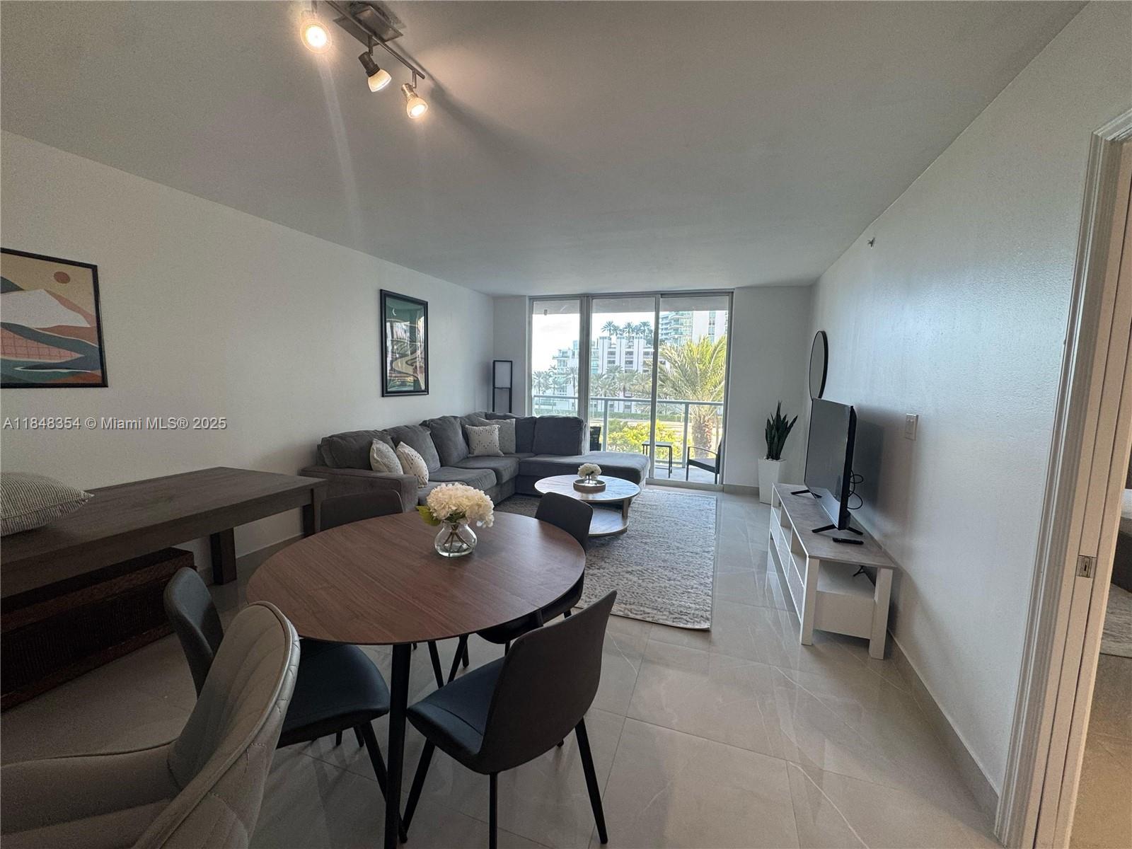 1155 Brickell Bay Drive, Unit 307 Miami, FL 33131 - Photo 5 of 23 a living room with furniture and a flat screen tv