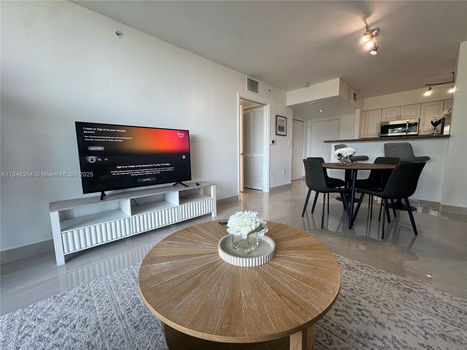 1155 Brickell Bay Drive, Unit 307 Miami, FL 33131 - Photo 7 of 23 a living room with furniture and a flat screen tv