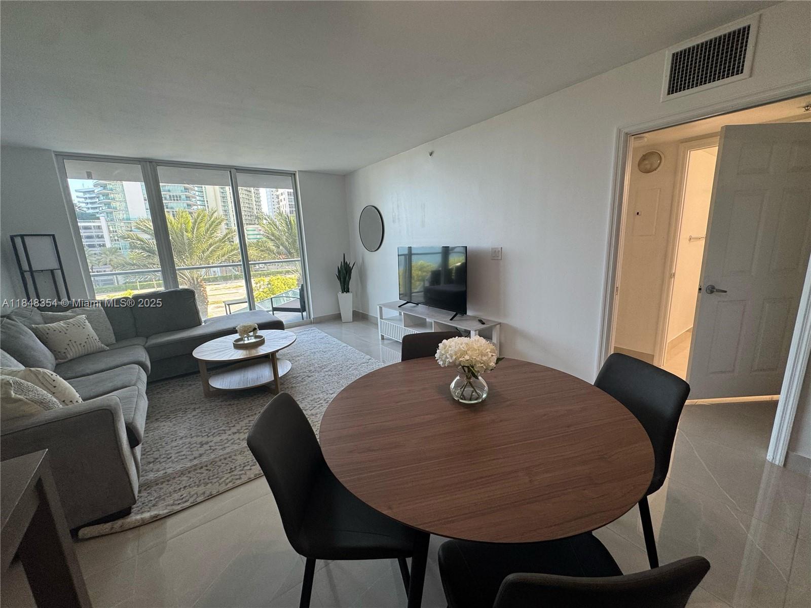 1155 Brickell Bay Drive, Unit 307 Miami, FL 33131 - Photo 10 of 23 a living room with furniture and wooden floor