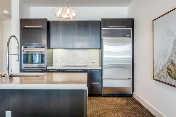 a living room with stainless steel appliances kitchen island granite countertop a rug a stove and a wooden floors