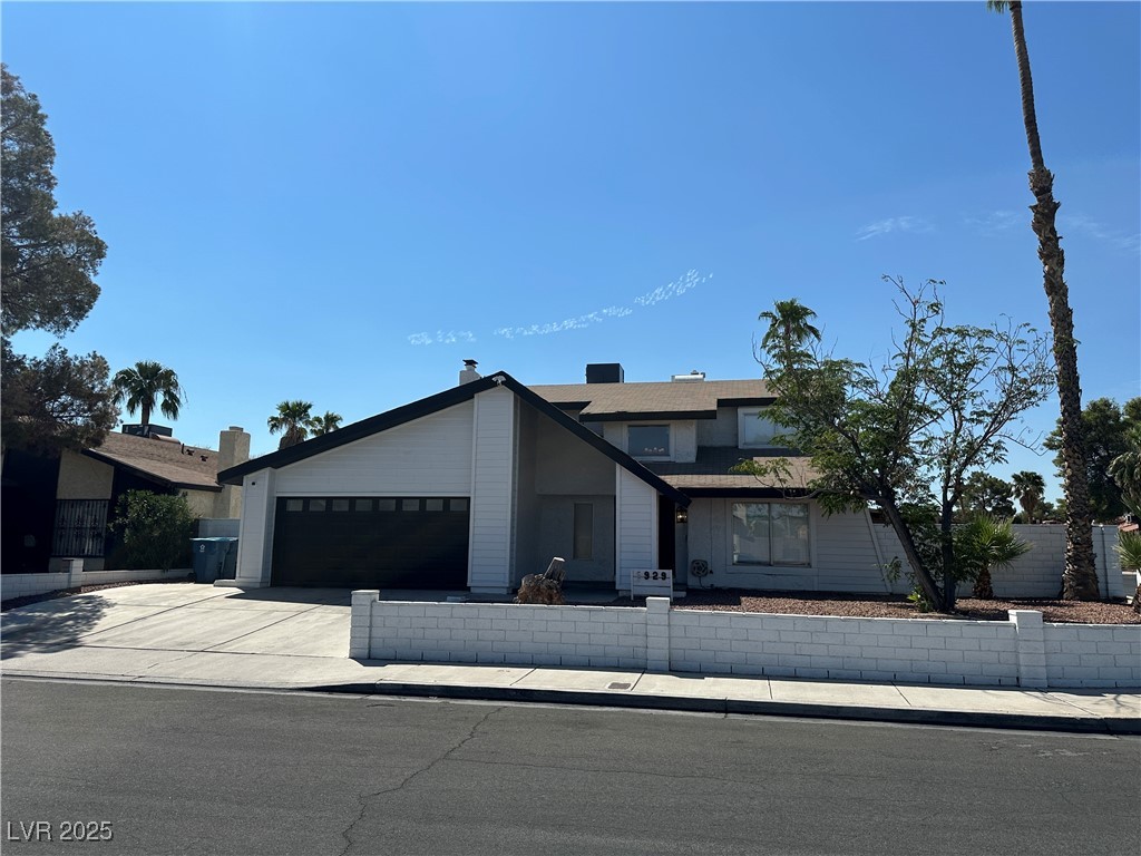 View of front of home with concrete driveway and a garage