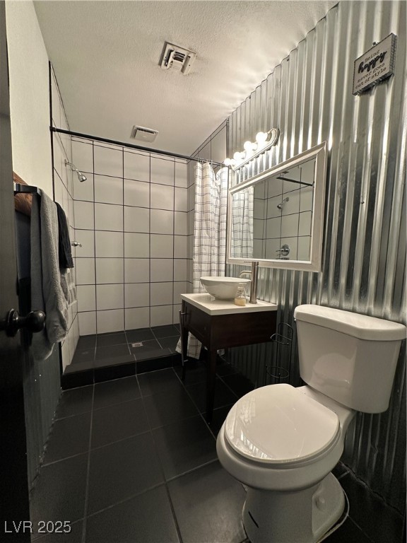5929 West Cherokee Avenue Las Vegas, NV 89103 - Photo 5 of 30 Full bath featuring dark tile patterned flooring, a shower stall, a textured ceiling, and vanity