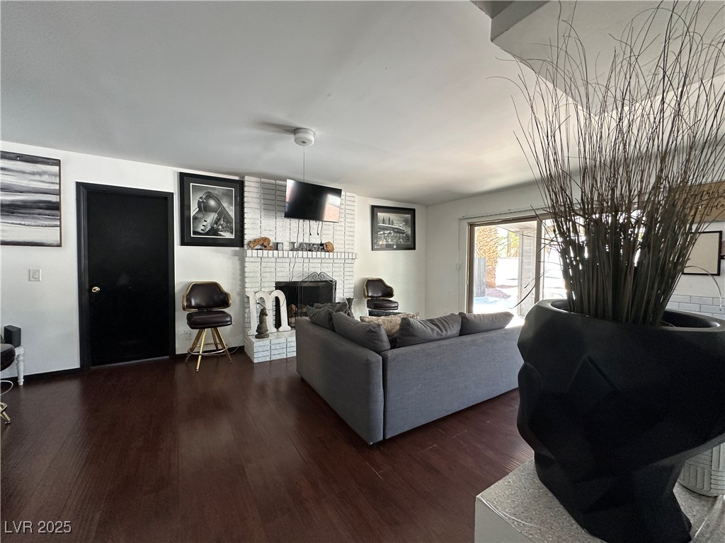 5929 West Cherokee Avenue Las Vegas, NV 89103 - Photo 6 of 30 Living area with dark wood finished floors and a fireplace