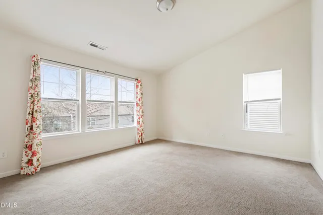 an empty room with windows and closet