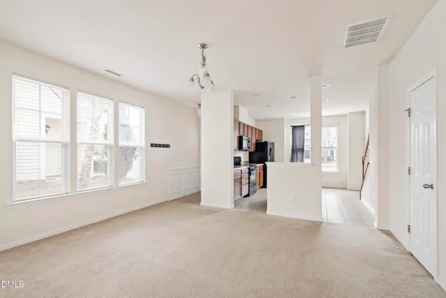 an empty room with windows and fireplace