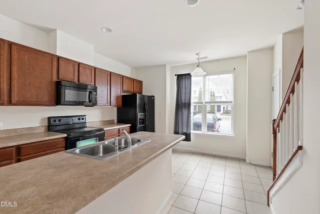 a kitchen with stainless steel appliances granite countertop a refrigerator stove microwave and sink