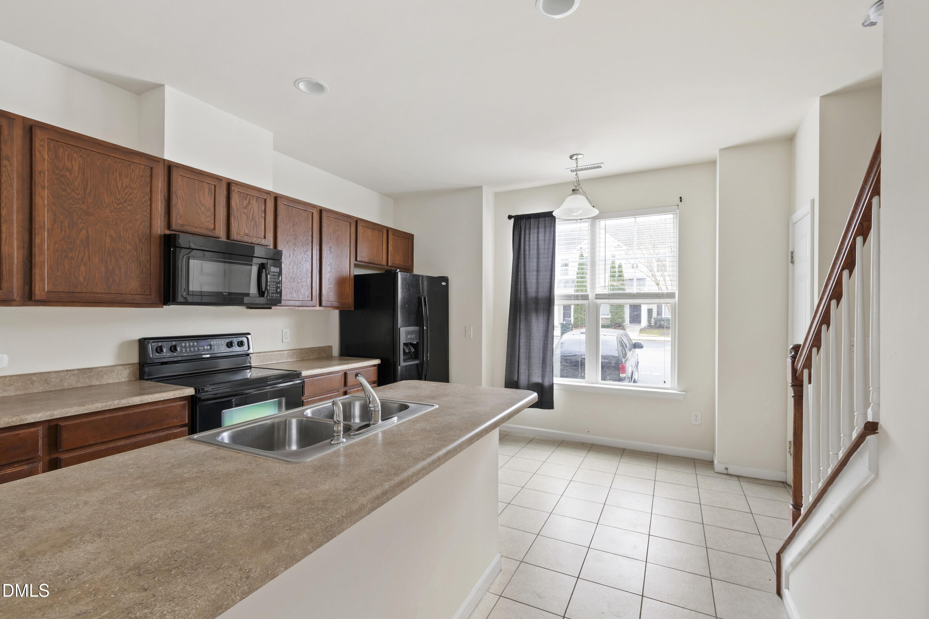 6617 Clarksburg Place Raleigh, NC 27616 - Photo 10 of 30 a kitchen with stainless steel appliances a refrigerator a stove a sink cabinets and a dining table
