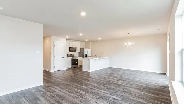 a view of kitchen with kitchen island wooden floor center island and stainless steel appliances