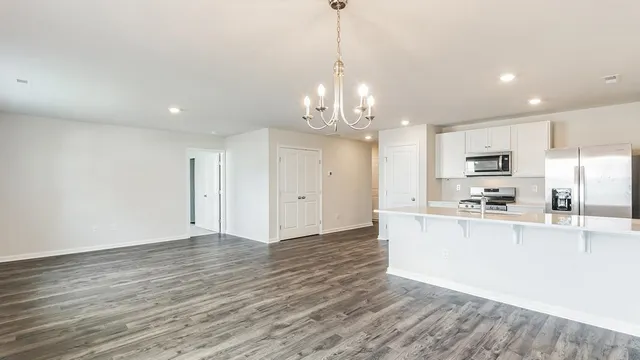 a view of a kitchen with wooden floor and stainless steel appliances