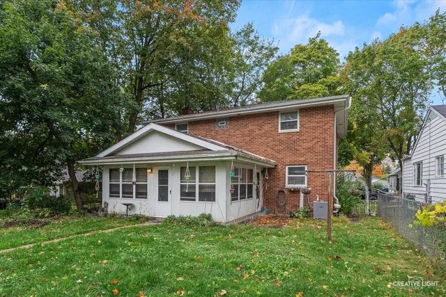 a backyard of a house with plants and large tree