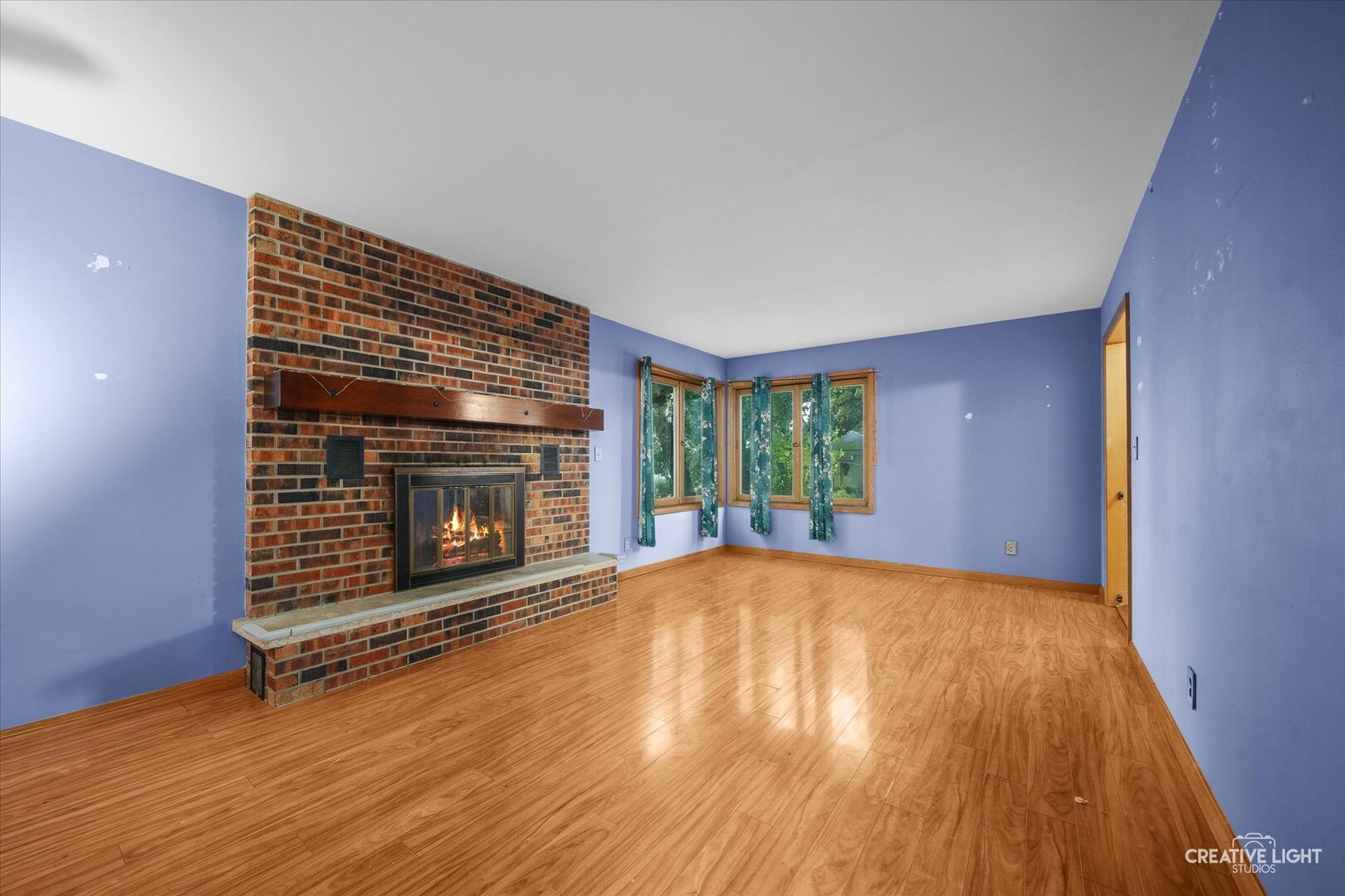 754 Haish Boulevard DeKalb, IL 60115 - Photo 2 of 20 a view of empty room with wooden floor and fireplace