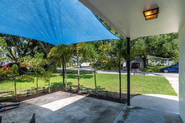 a view of a backyard with table and chairs under an umbrella