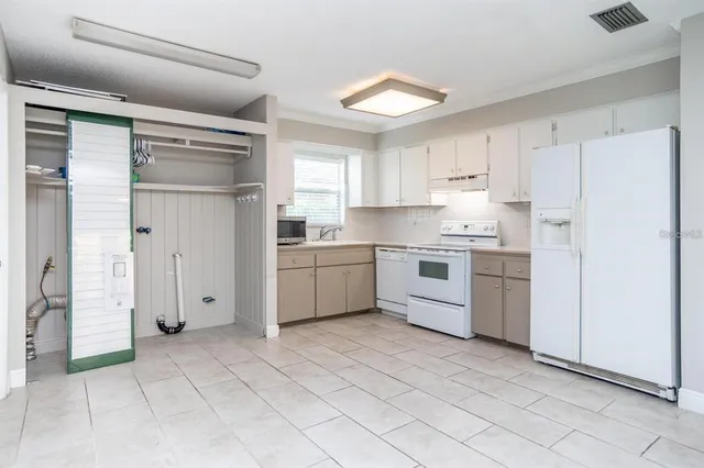 a kitchen with white cabinets and white appliances