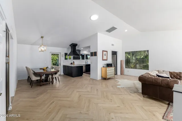 a living room with furniture and kitchen area