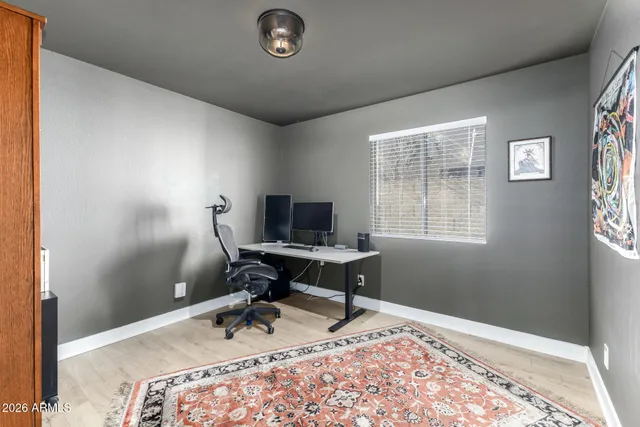 a view of a workspace with furniture and a window