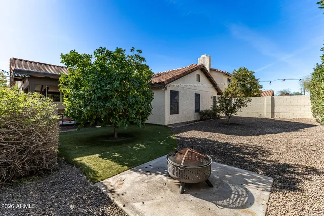 a view of a white house with a yard and potted plants