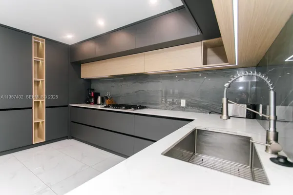 a kitchen with stainless steel appliances a sink a stove and a refrigerator