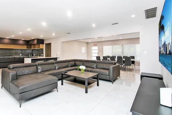 a living room with furniture and a view of kitchen
