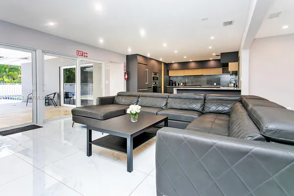 a living room with stainless steel appliances kitchen island granite countertop furniture and a large window