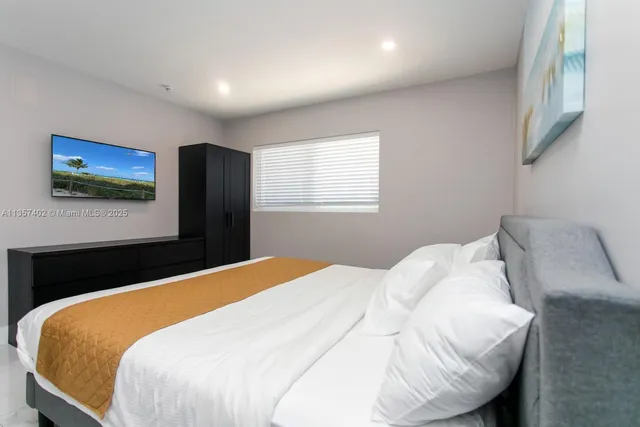 a bedroom with a bed and a flat screen tv