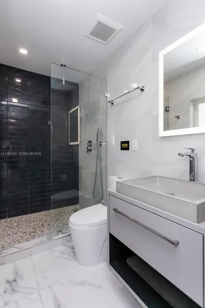 a bathroom with a double vanity sink toilet and shower