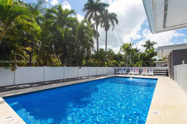 a view of a swimming pool with a chair and potted plants