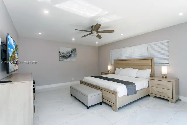 a bedroom with a balcony a bed and glass walk in closet