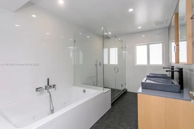 a bathroom with a tub a sink and mirror