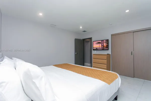 a bedroom with a bed and a flat screen tv