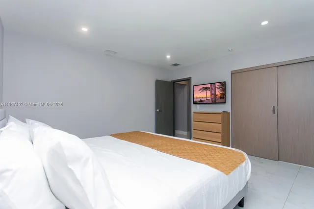 a bedroom with a bed and a flat screen tv