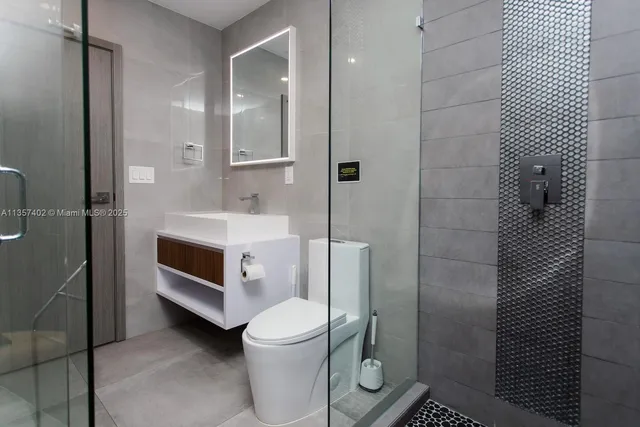 a bathroom with a sink a toilet and shower