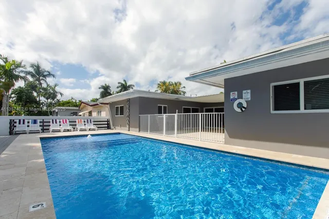 a front view of a house with swimming pool and deck