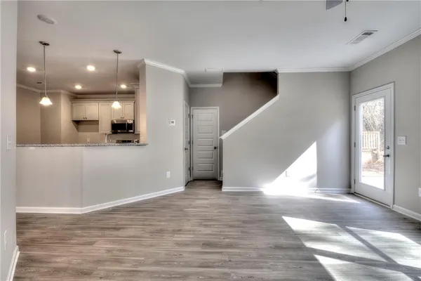 a view of a hallway with wooden floor and kitchen