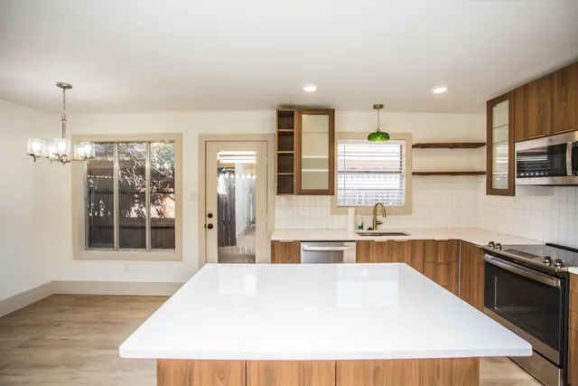 a view of a livingroom with wooden floor and a ceiling fan