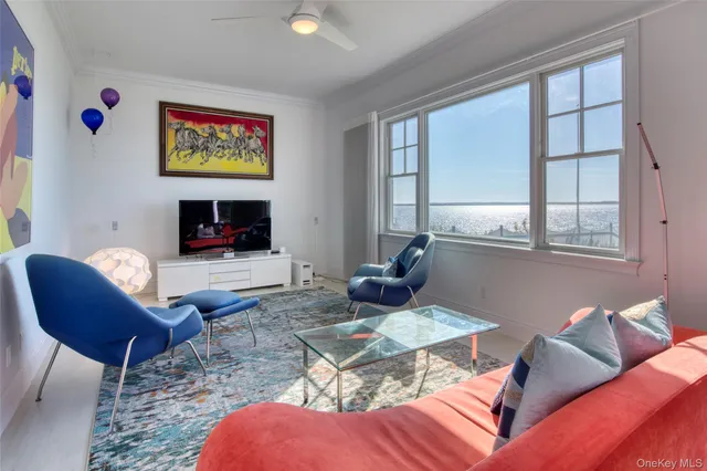a living room with furniture kitchen view and a window