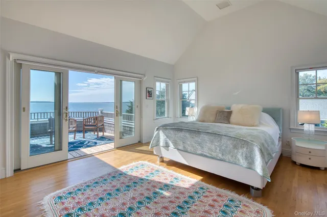 a spacious bedroom with a bed and wooden floor