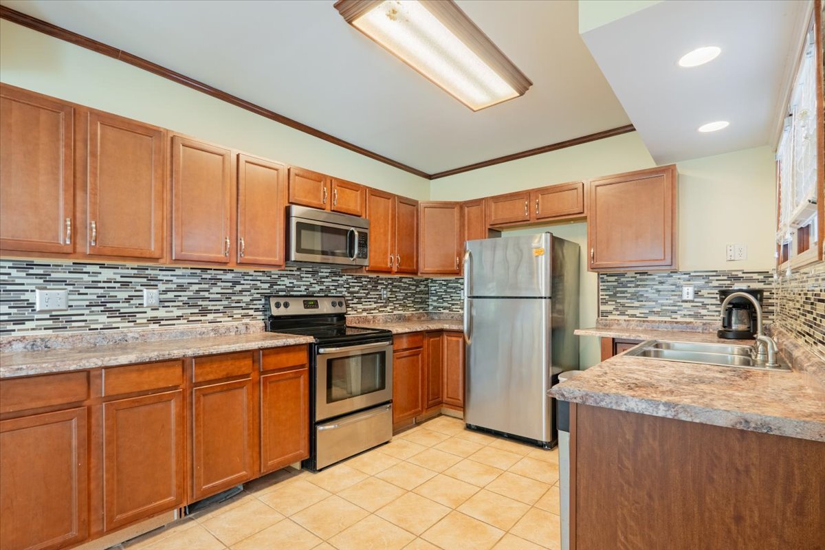603 South Main Street Eureka, IL 61530 - Photo 12 of 32 a kitchen with stainless steel appliances granite countertop a refrigerator a sink dishwasher a stove with wooden cabinets and floor