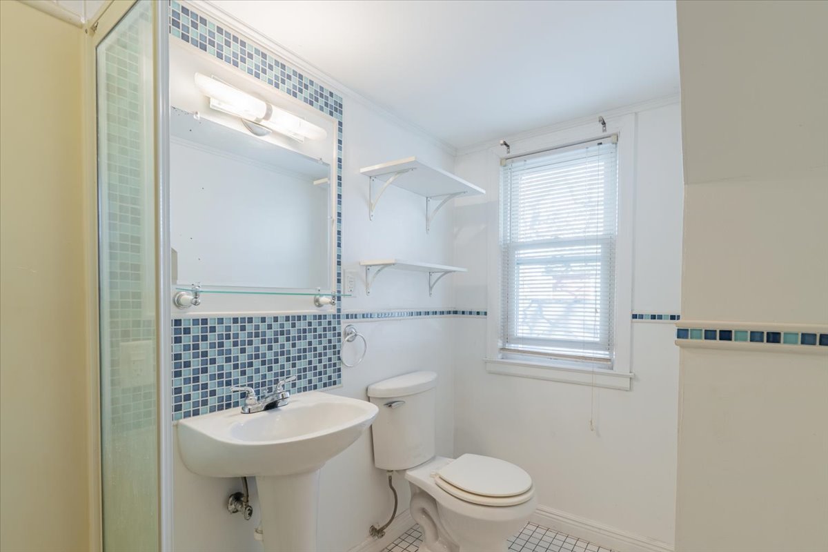 603 South Main Street Eureka, IL 61530 - Photo 23 of 32 a bathroom with a sink a toilet a window and shower