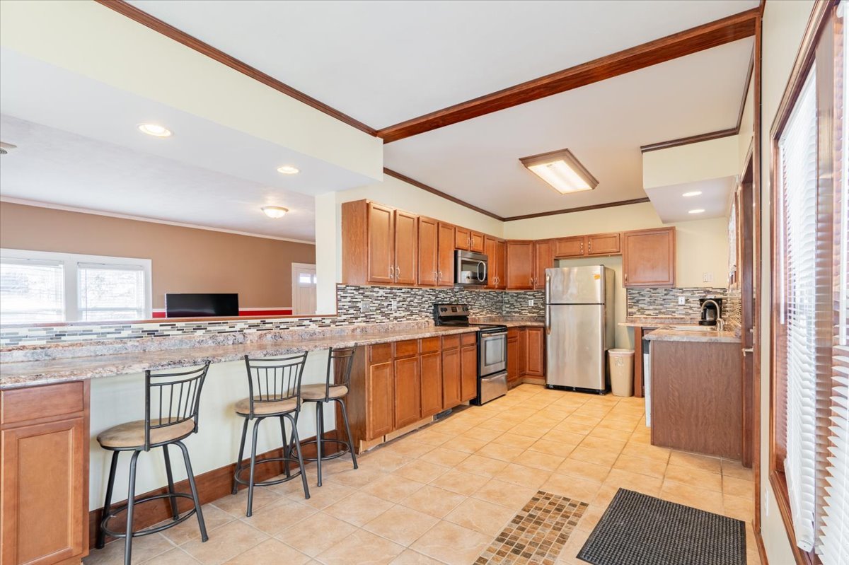 603 South Main Street Eureka, IL 61530 - Photo 10 of 32 a kitchen with stainless steel appliances kitchen island granite countertop a table chairs sink and cabinets