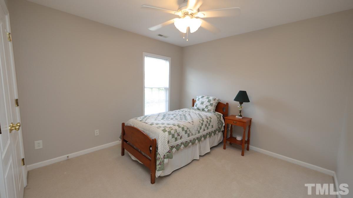 5410 Wind Mountain Lane Raleigh, NC 27613 - Photo 11 of 13 a spacious bedroom with a bed and a chandelier