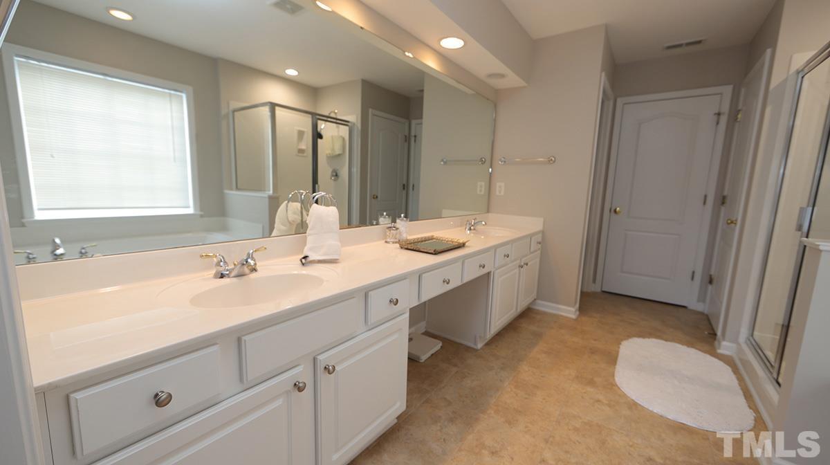 5410 Wind Mountain Lane Raleigh, NC 27613 - Photo 8 of 13 a spacious bathroom with a double vanity sink a mirror and a bathtub