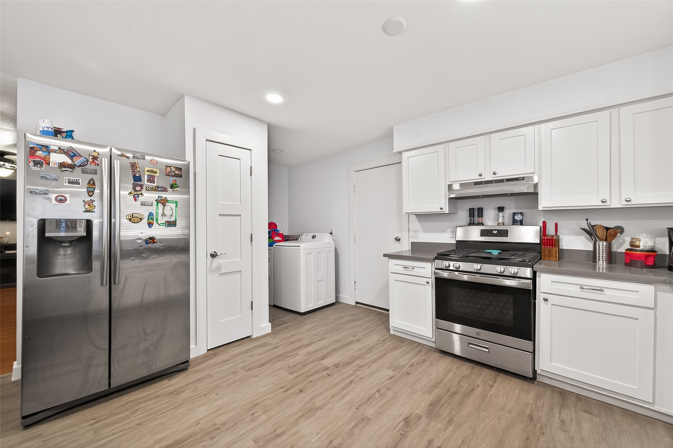 229 Austin Street Angleton, TX 77515 - Photo 13 of 36 a kitchen with granite countertop a refrigerator stove and wooden cabinets