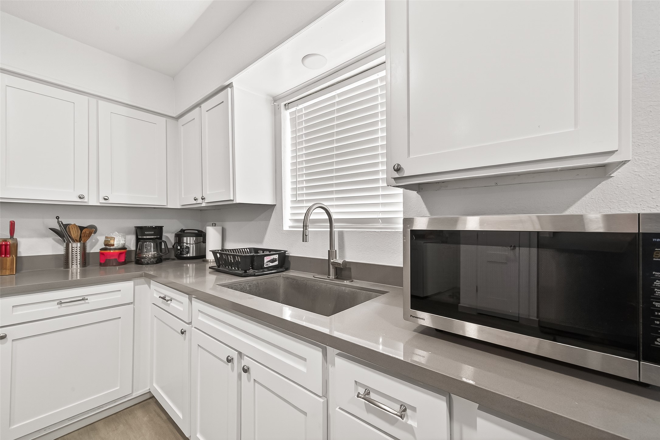 229 Austin Street Angleton, TX 77515 - Photo 17 of 36 a kitchen with granite countertop white cabinets and white appliances