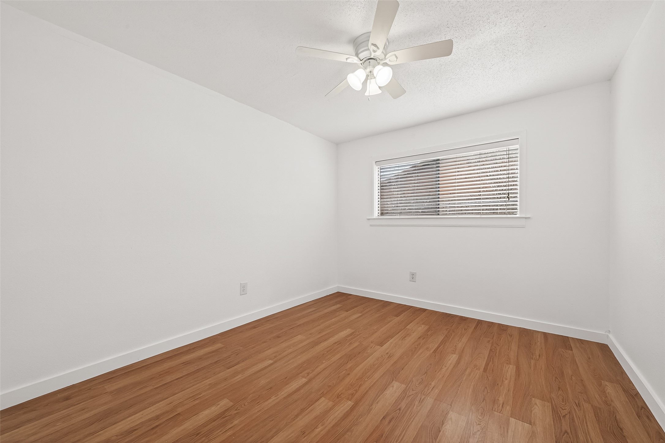 229 Austin Street Angleton, TX 77515 - Photo 19 of 36 an empty room with wooden floor and window