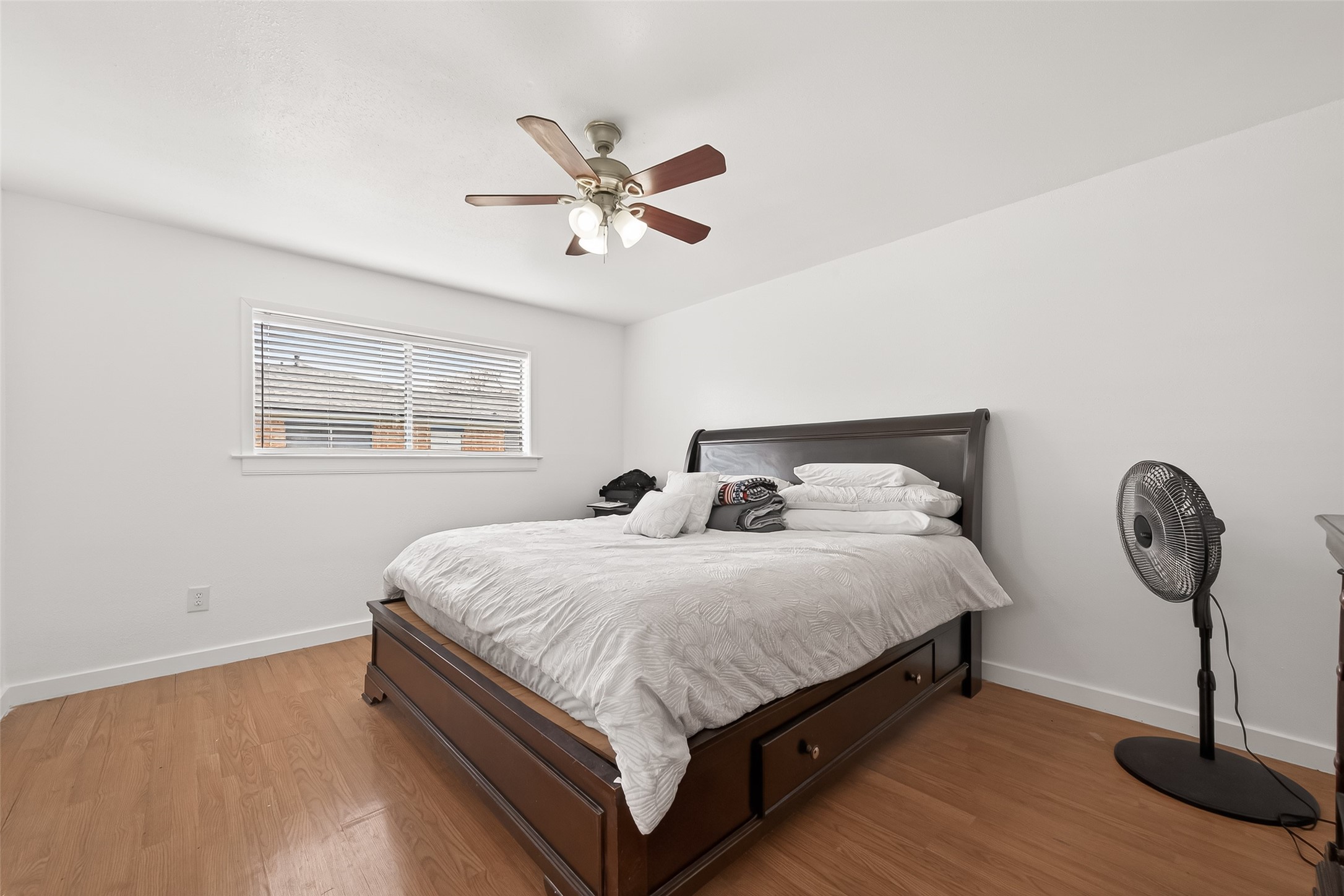 229 Austin Street Angleton, TX 77515 - Photo 24 of 36 a large bed sitting in a bedroom next to a window with a chandelier