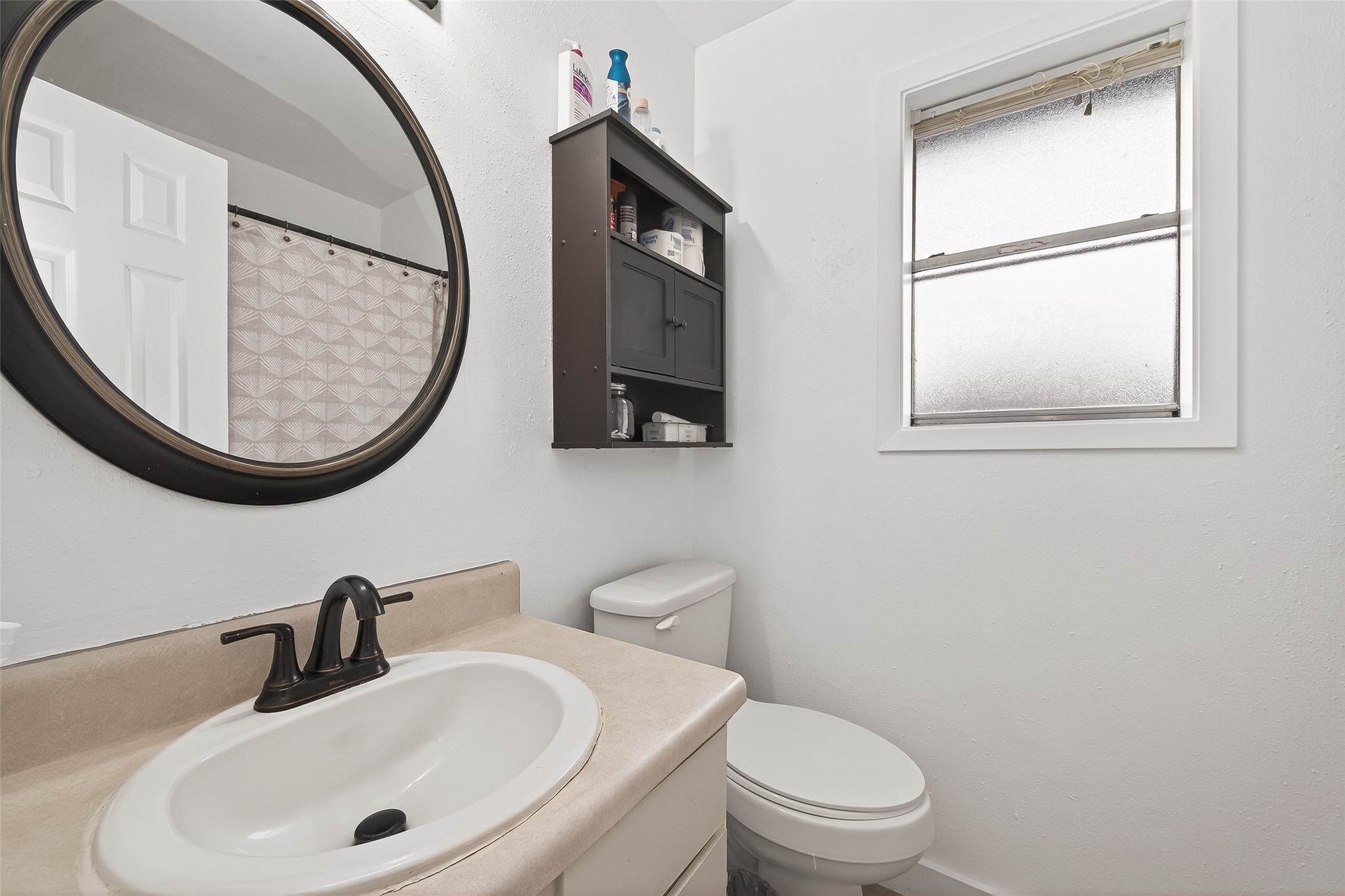 229 Austin Street Angleton, TX 77515 - Photo 27 of 36 a bathroom with a toilet a sink and a mirror