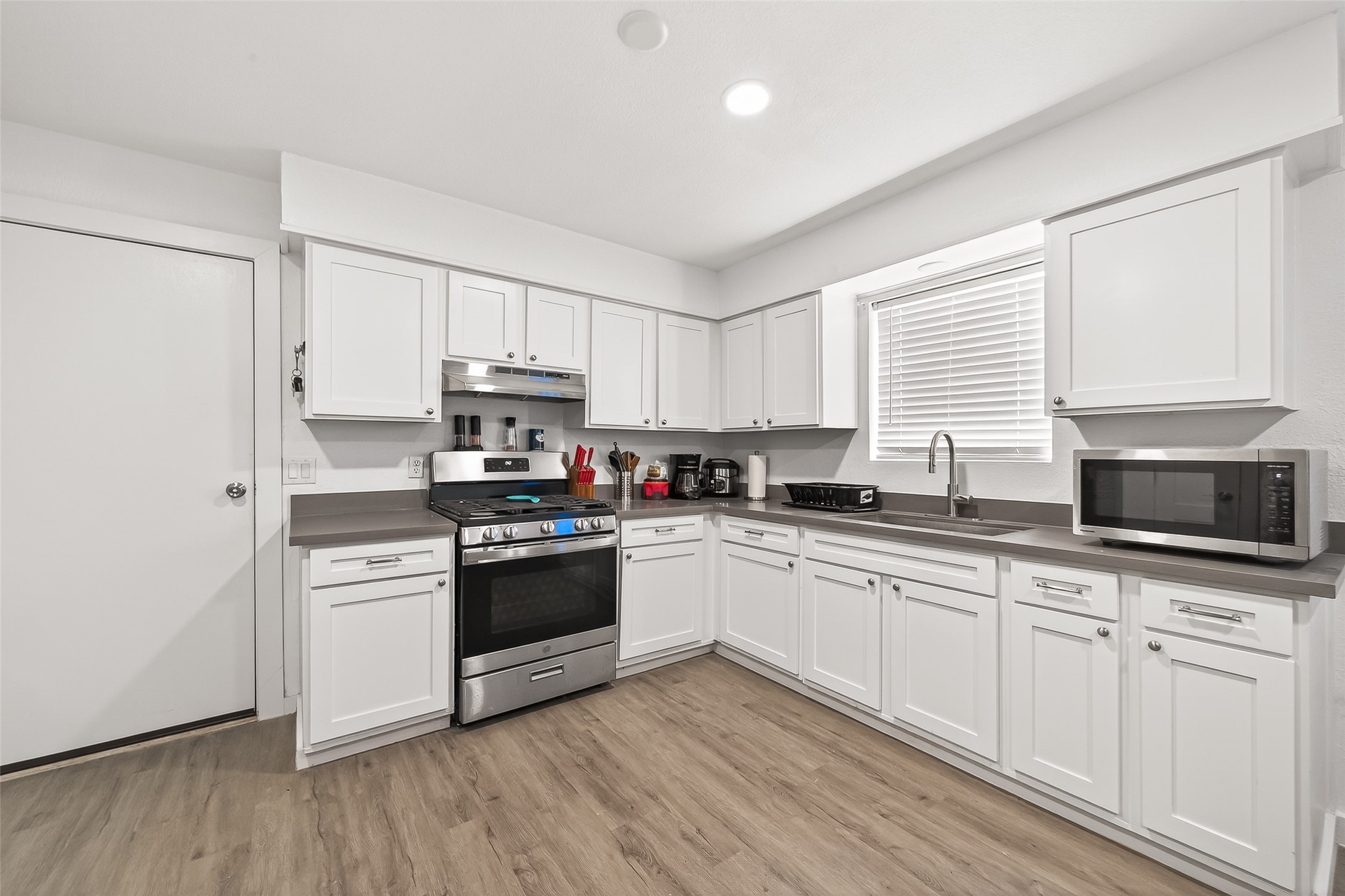 229 Austin Street Angleton, TX 77515 - Photo 10 of 36 a kitchen with granite countertop white cabinets and stainless steel appliances